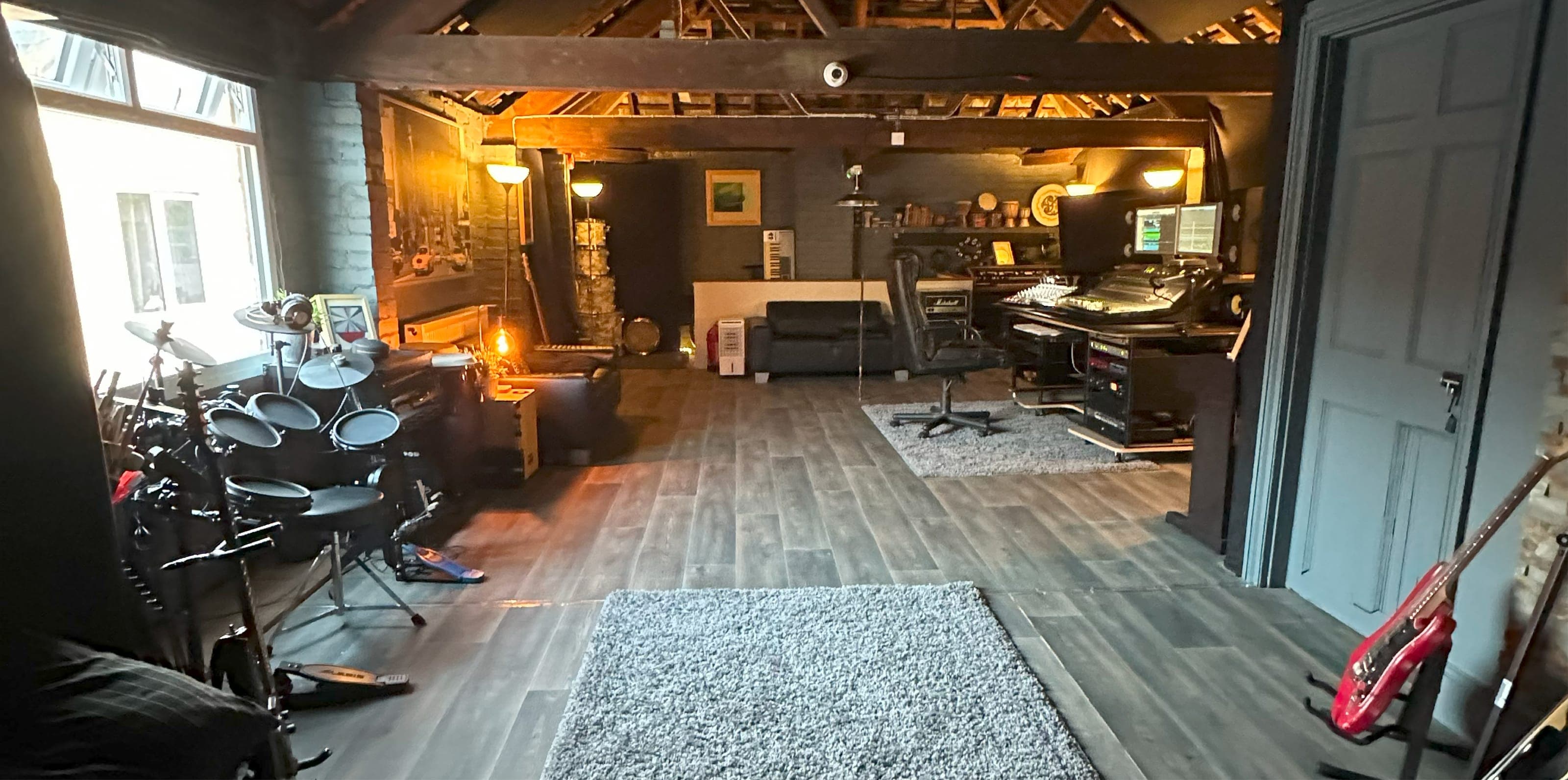 Panorama of the studio: live room, drum kit and control room under the timber roof