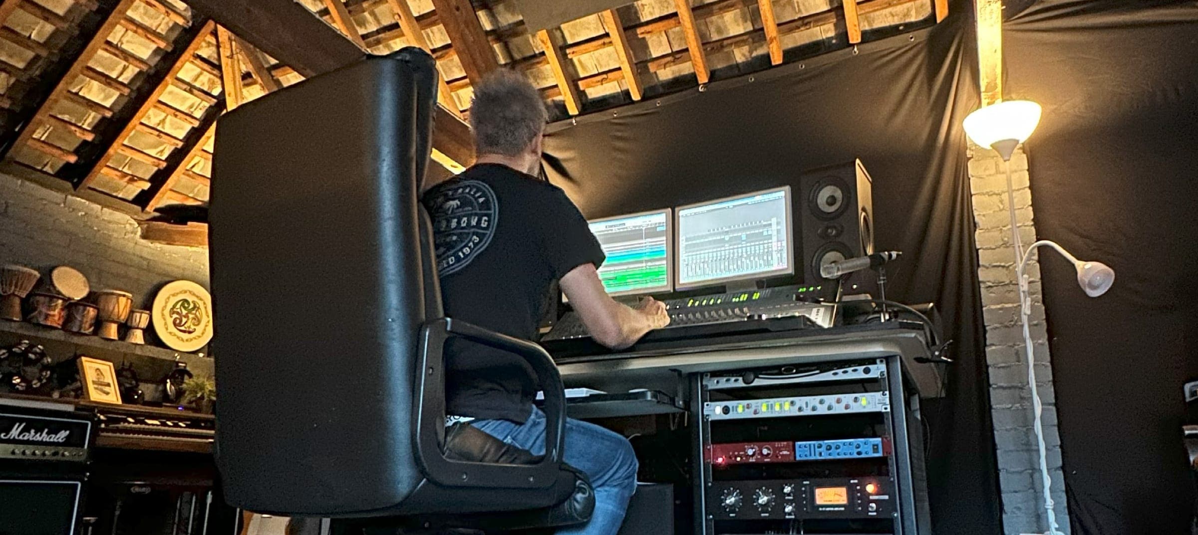 Producer at the desk in the studio under the exposed timber roof