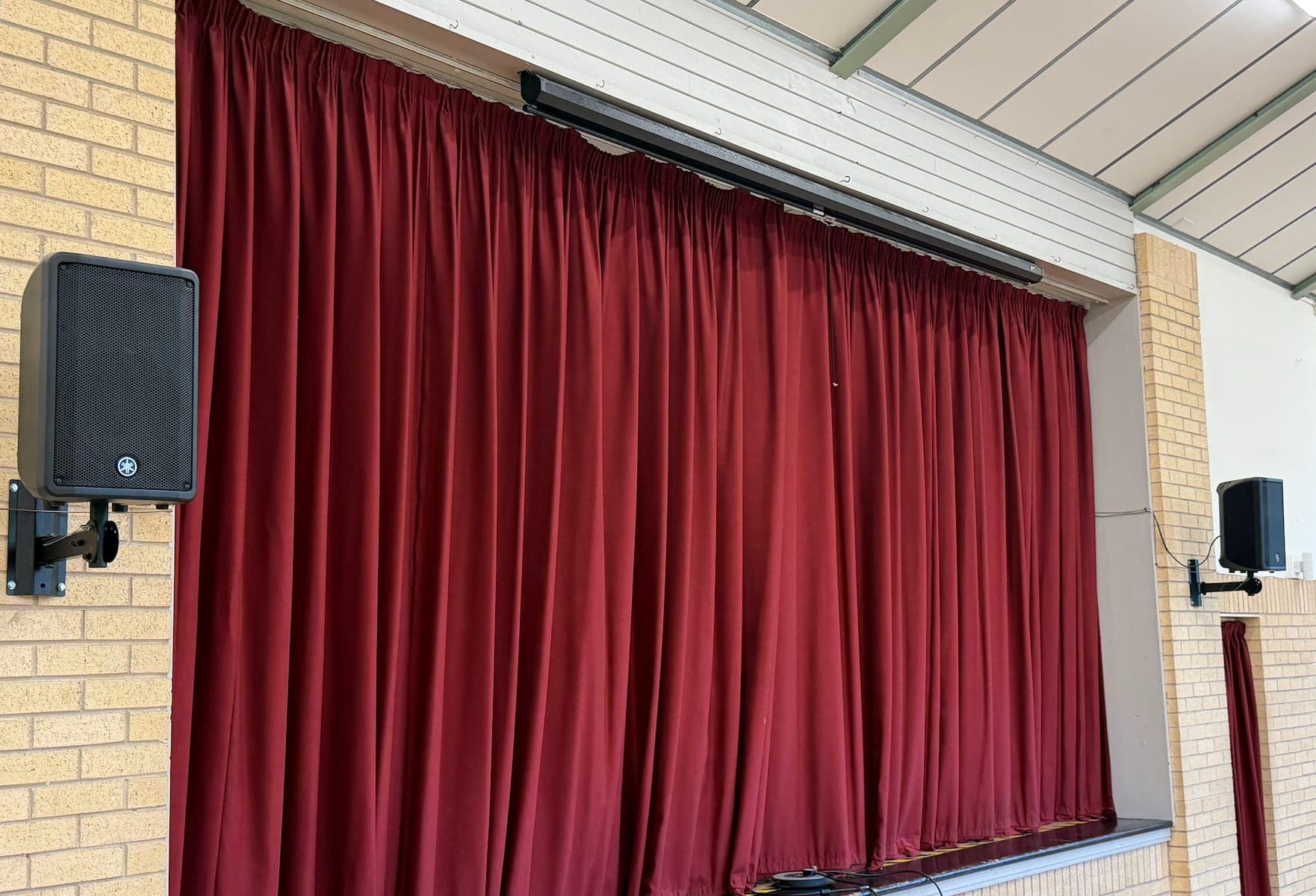 Hall stage with wall-mounted speakers either side