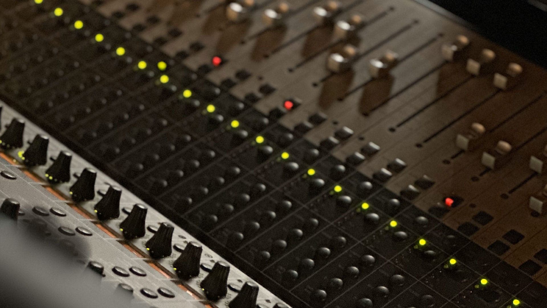 Close-up of mixing desk faders and meters