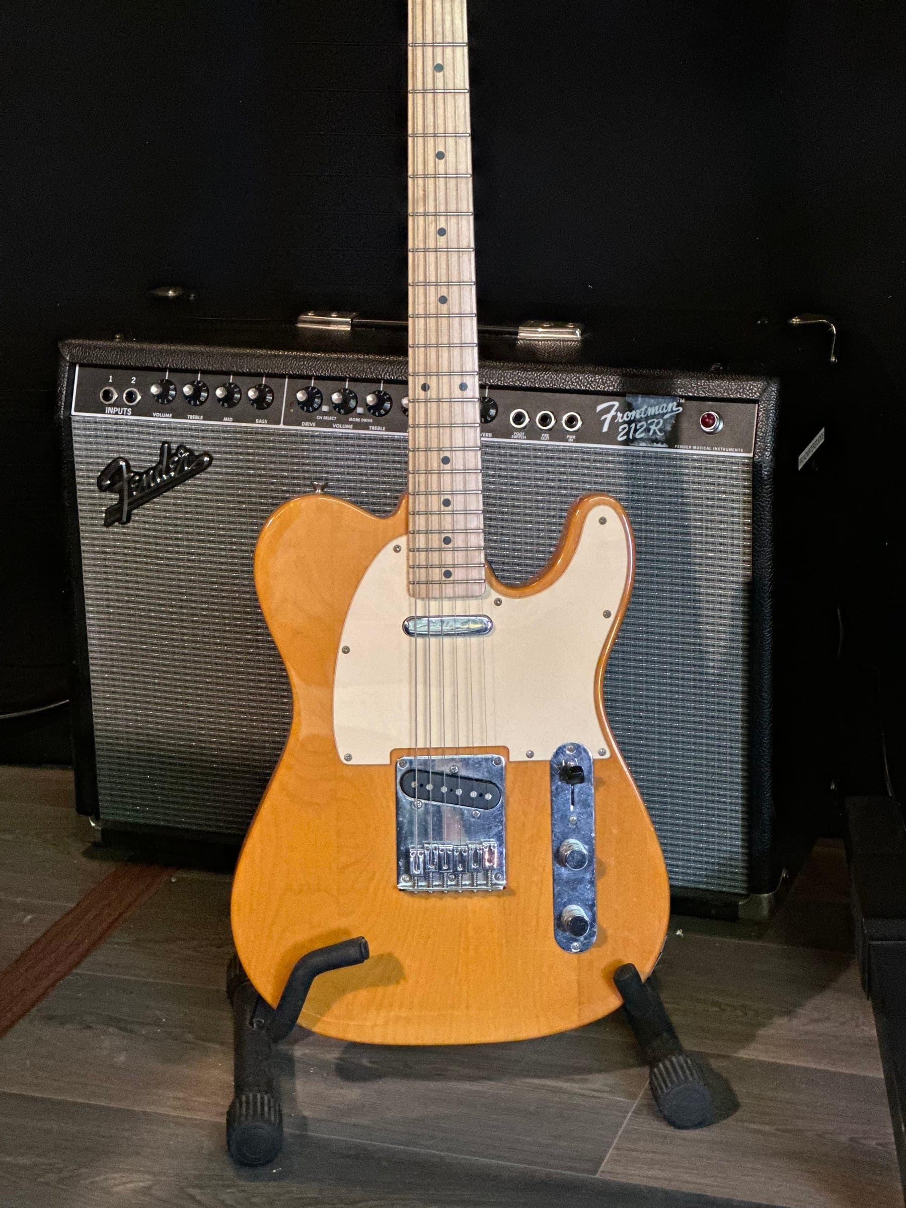 Fender Telecaster on a stand in front of a Fender amplifier